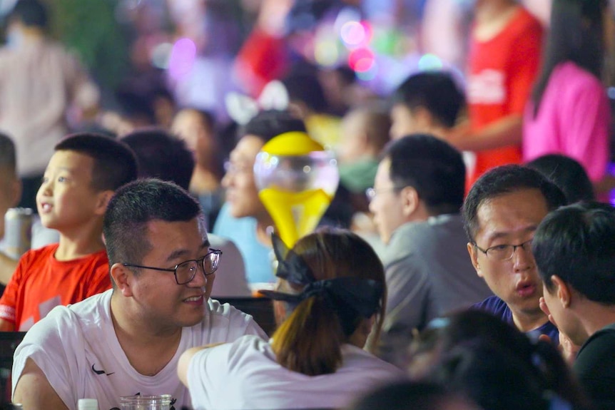 A group of people sitting in a crowded beer festival