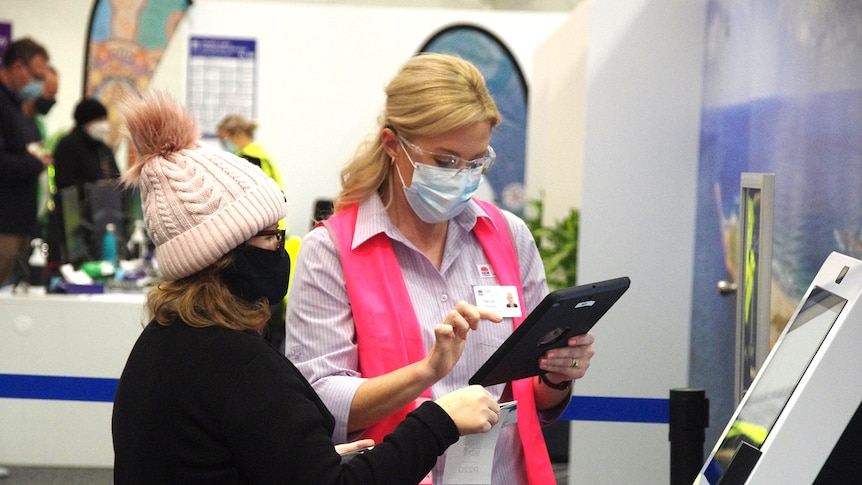 Staff from Hunter New England Health assist people as they arrive at Belmont mass vaccination hub