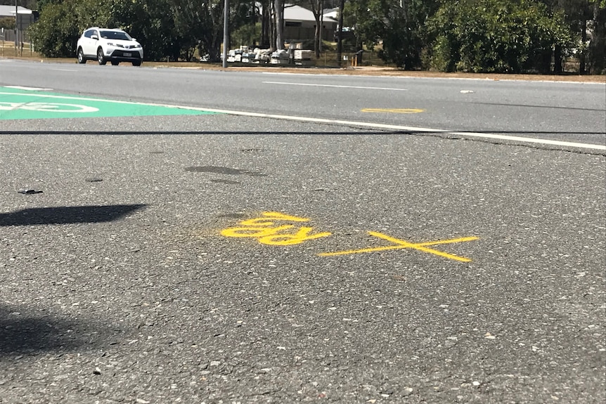 A picture of the road where the hit and road took place. An x is marked on the pavement in yellow.