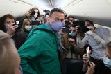 Alexei Navalny is surrounded by journalists inside the plane prior to his flight to Moscow.