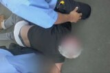 Security footage shows a V/line train passenger being held on the ground for drinking on a train