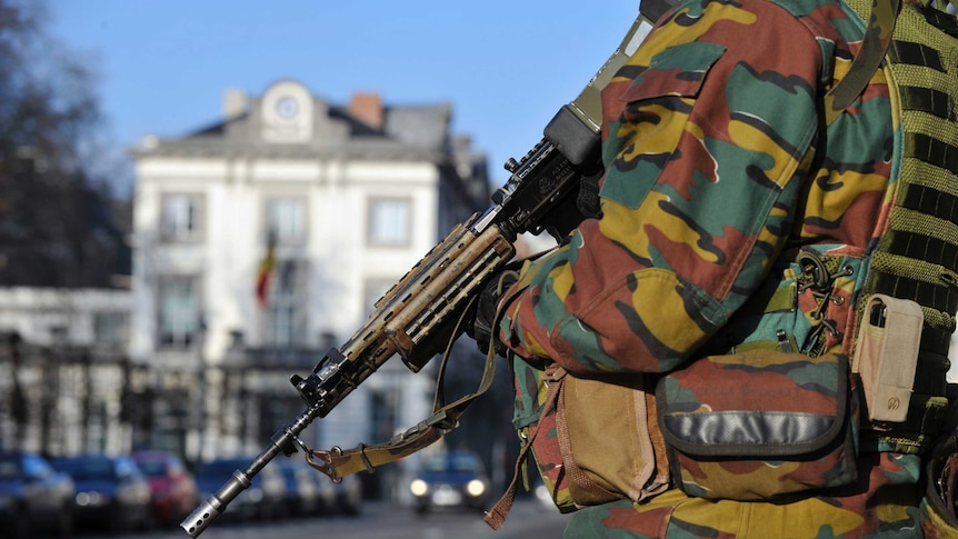 A Belgian paratrooper stands guards outside the US Embassy in Brussels