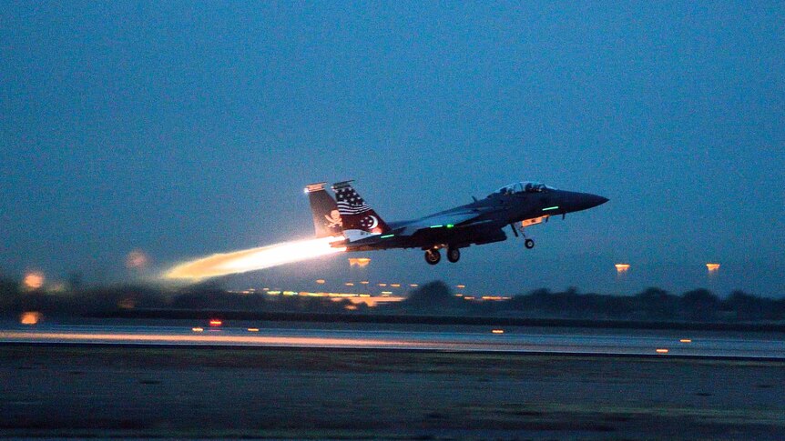 An F15 takes off from a runway.