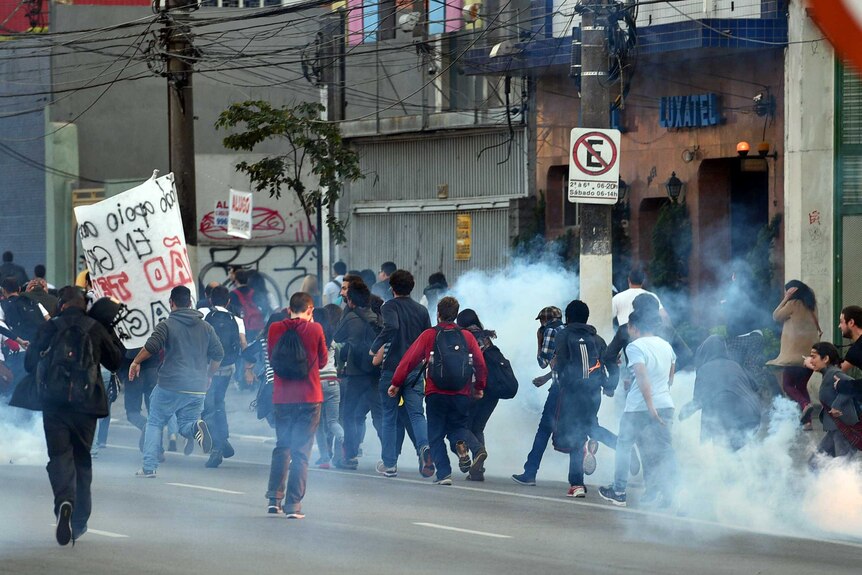 Protesters run after police fire tear gas in Sao Paulo