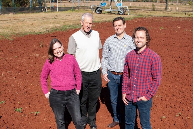 four people standing in a irrigated research paddock