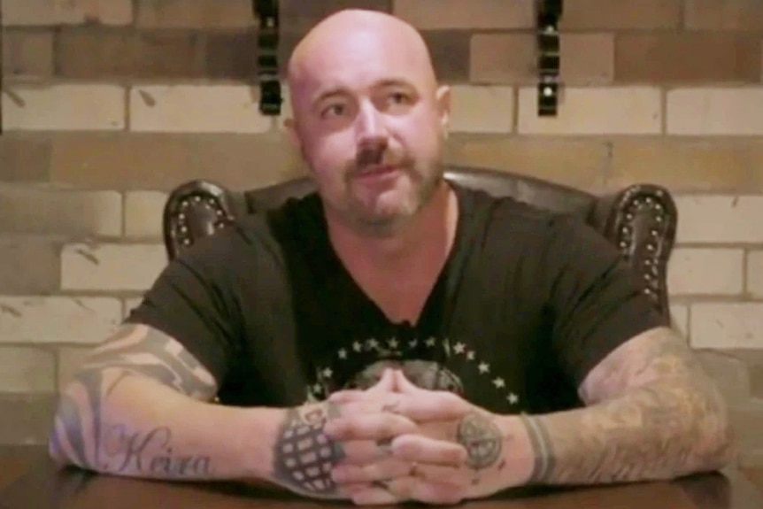 A bald man wearing a black T-shirt