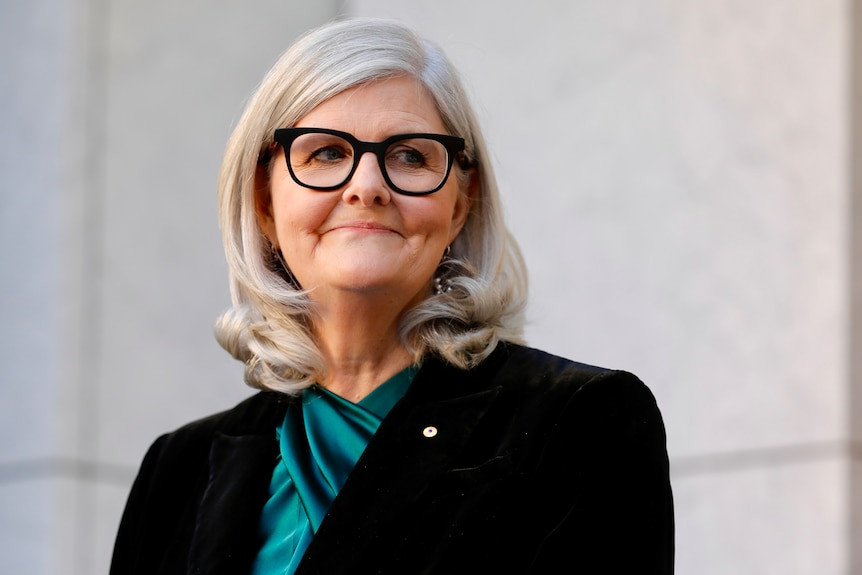 Woman with black glasses smiles 