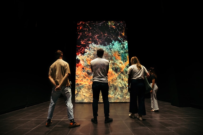 People stand in front of an exhibition.