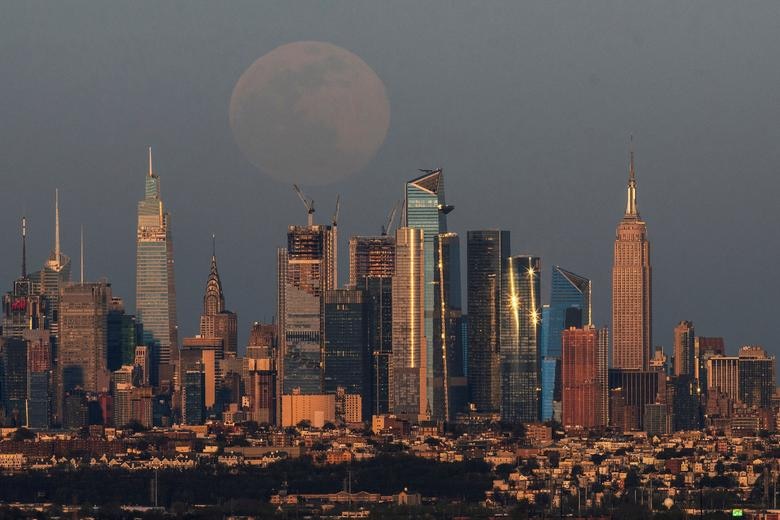 A "Super Pink Moon", rises over the skyline of New York and Empire State Building