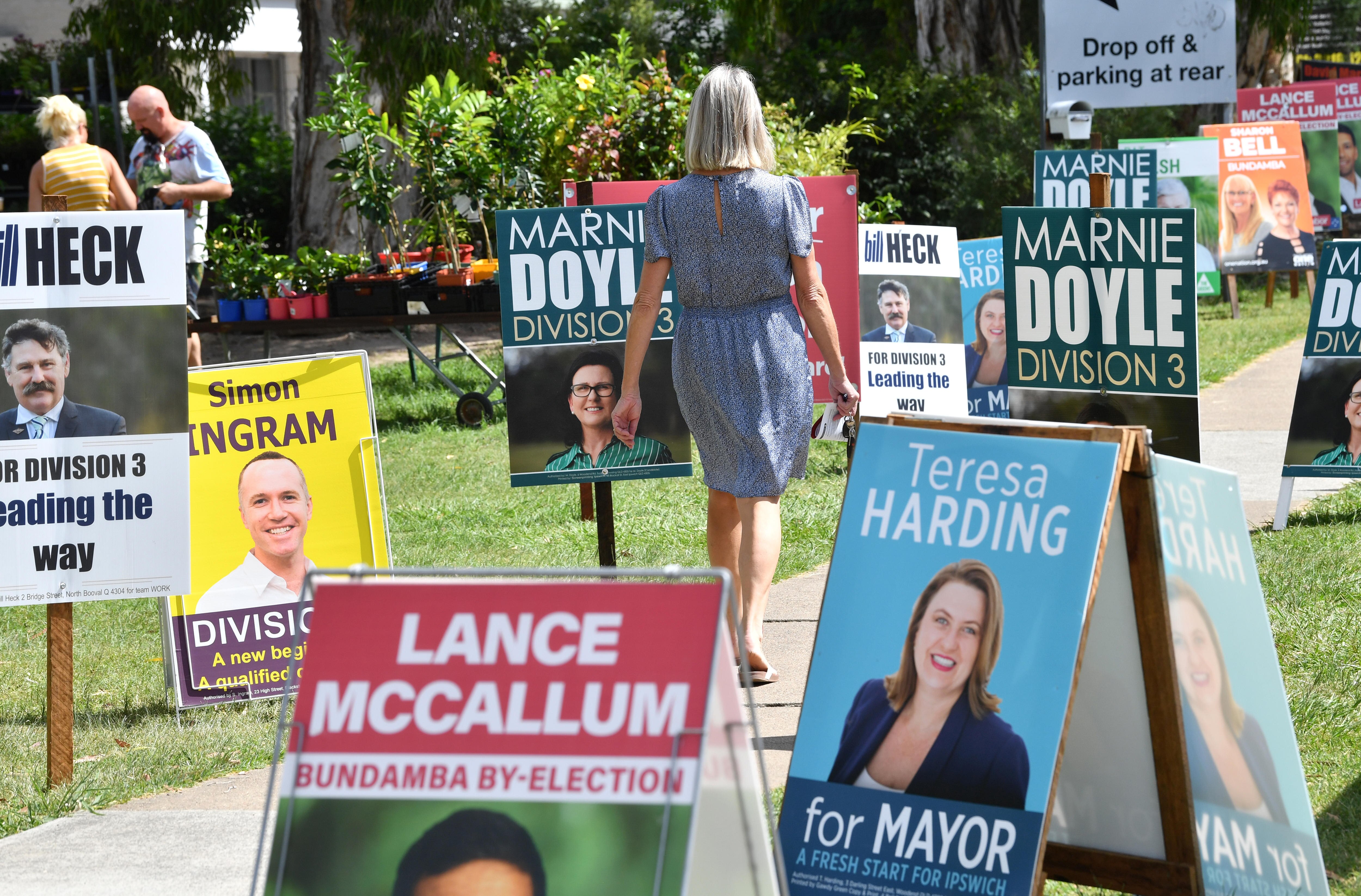 a woman walking among candidate signs