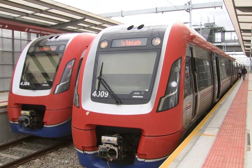 Two red trains at a station