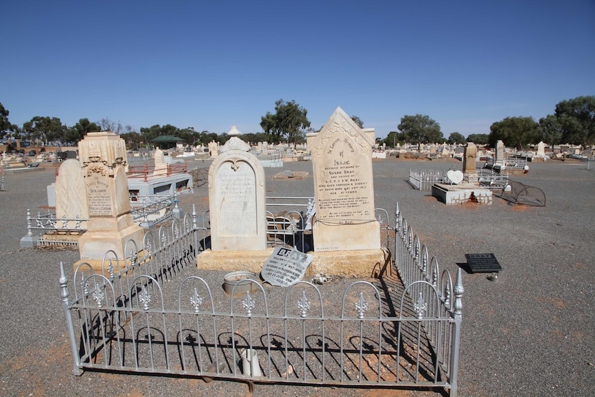 Historic headstones surrounded by a fence.