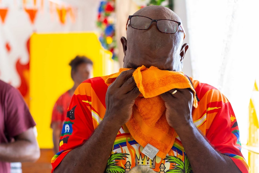 A man wearing glasses, crying in church.