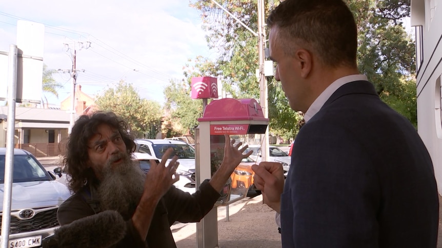 A protester opposed to industrial development on Adelaide's parklands confronts SA Premier Peter Malinauskas.