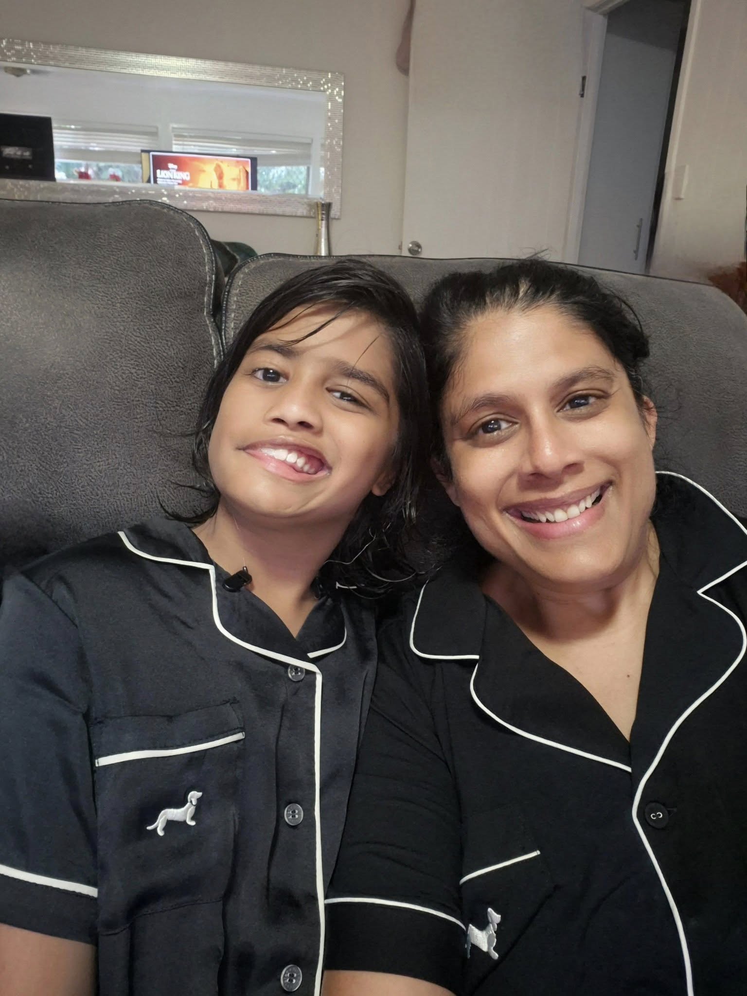 Niti and her daughter take a selfie on the couch in their PJs