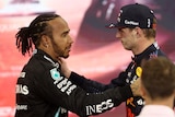 Two race drivers embrace after a hard fought race.