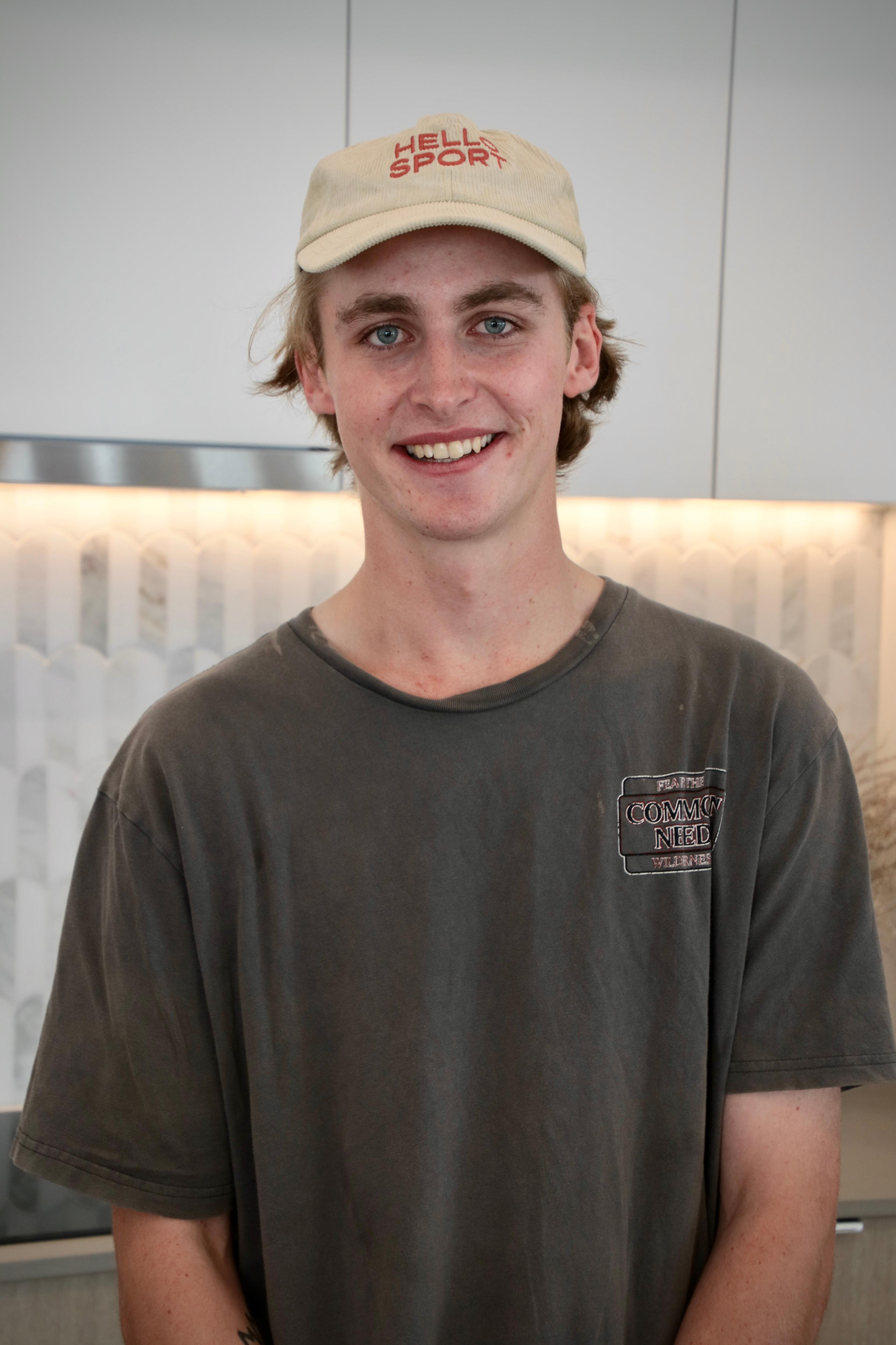 a young man wearing a cap smiling