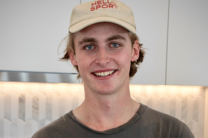 a young man wearing a cap smiling