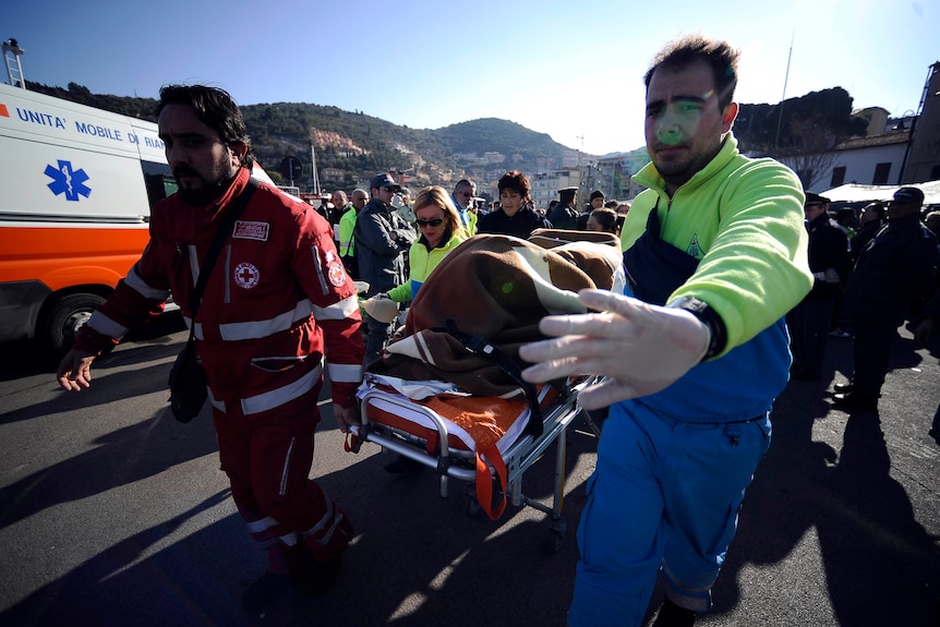 Medicals workers carry a passenger of the Costa Concordia