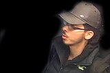 Salman Abedi wears blue jeans, a dark jacket and grey cap. His surroundings have been digitally removed.