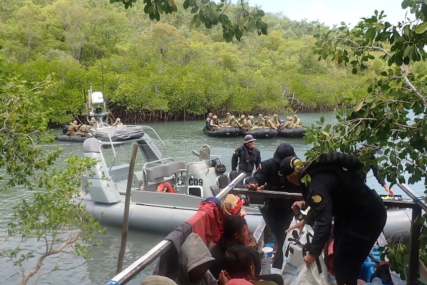 Australian Border Force boat pins a fishing boat against mangroves