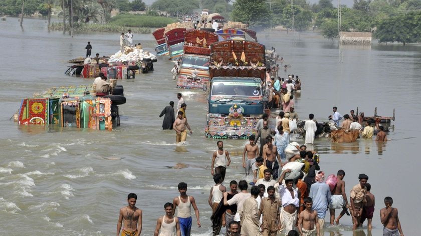 Flood victims cross a flooded road