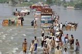 Flood victims cross a flooded road