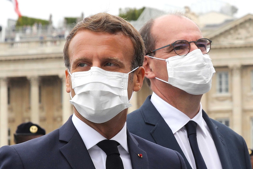 France's President Emmanuel Macron, left, and Prime Minister Jean Castex wear face masks as they attend the Bastille Day parade.