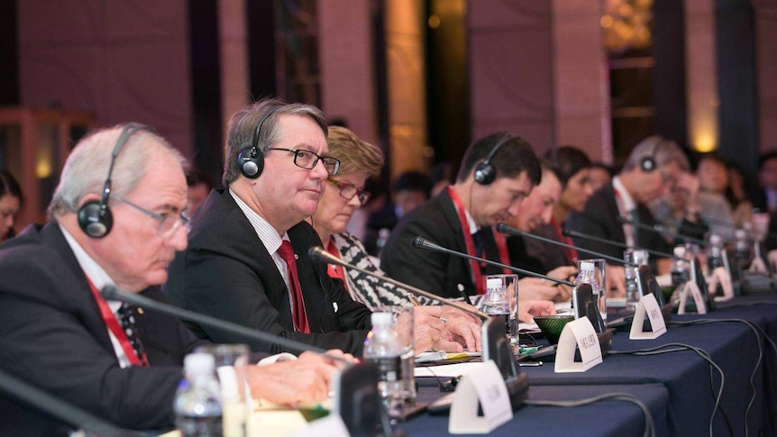 Warwick Smith sitting at a conference about China-Australia relations.