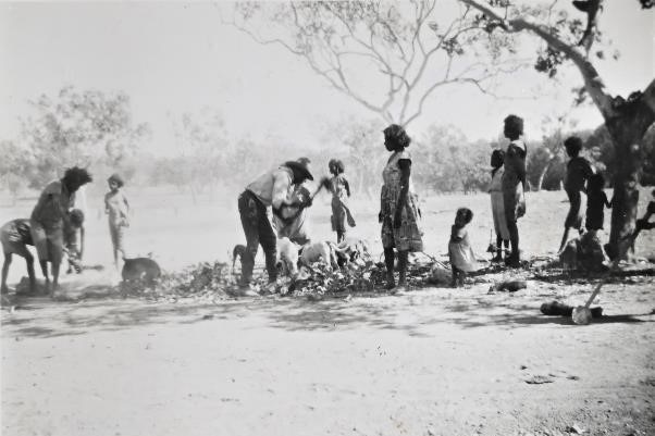 A clan of Indigenous people gather around livestock killed on a cattle farm. 