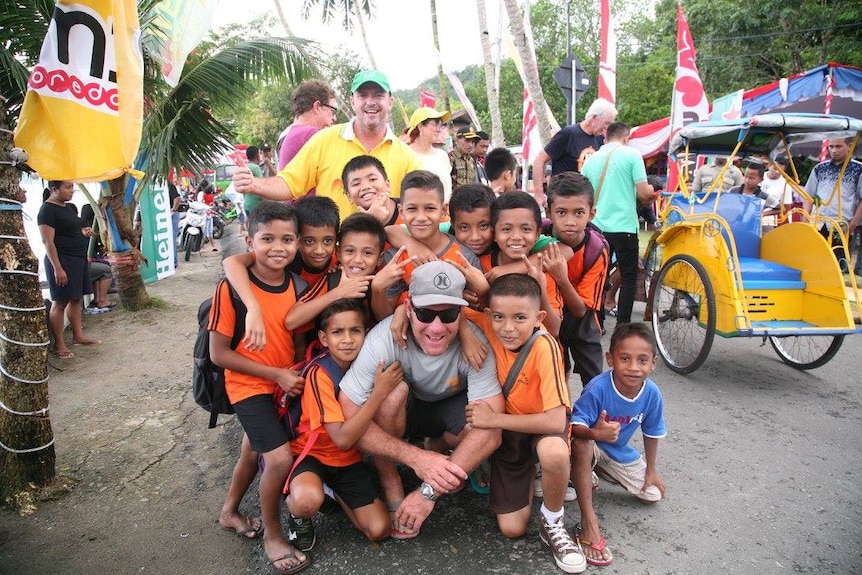 Indonesian children crowded around sailors.