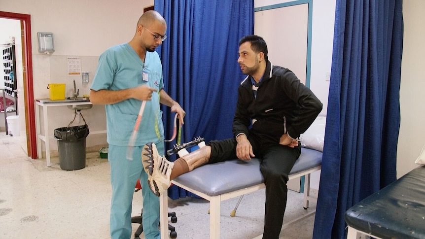 A patient with a leg injury speaks to a physiotherapist.