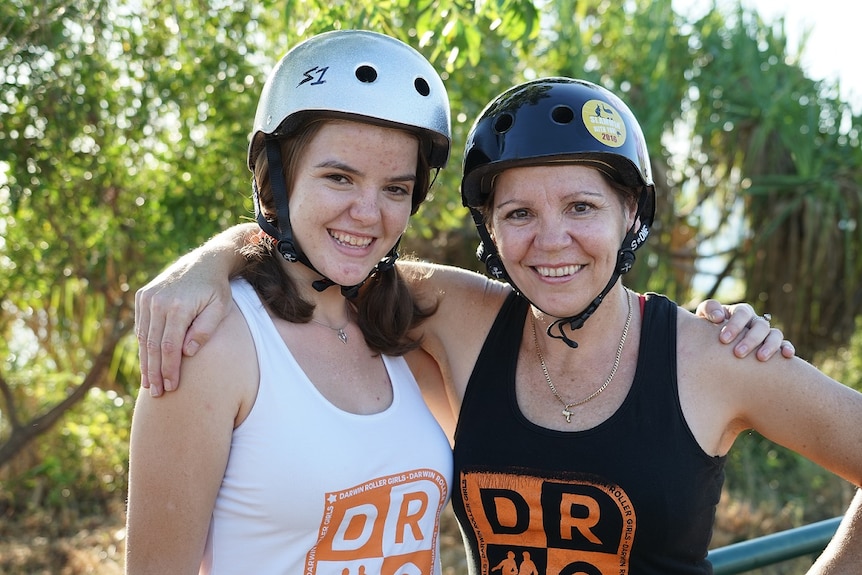 Karen and Eloise Avery wearing roller derby helmets.
