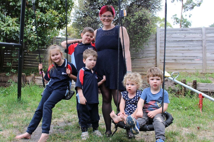 Tasmanian mum Cass Whitehill with her children on a backyard swingset.