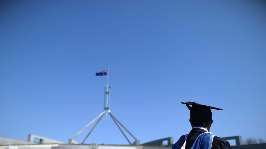 A university graduate looks at Parliament House in Canberra.