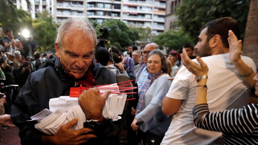 A man holds ballots at a polling station