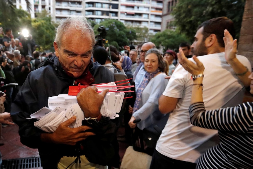 A man holds ballots at a polling station