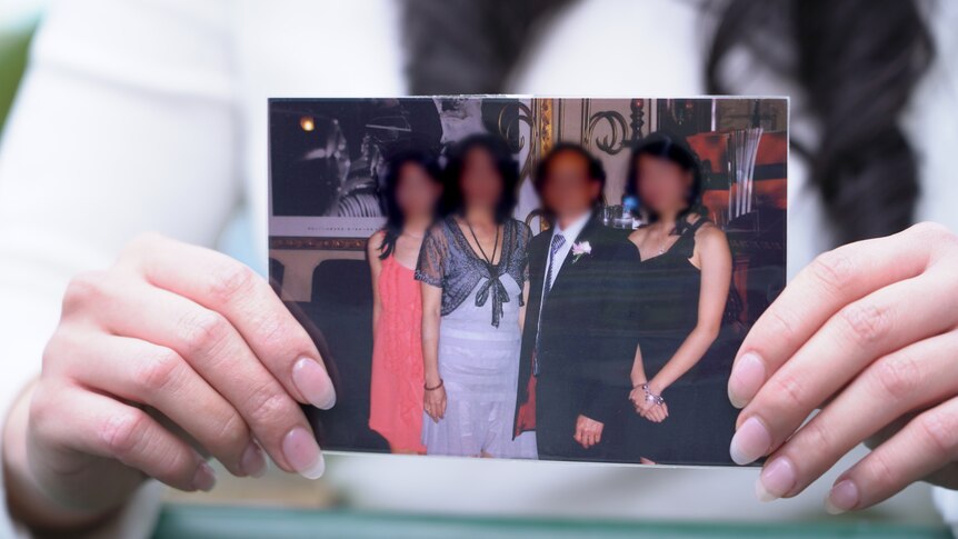 A family photo of four people, with their faces blurred.