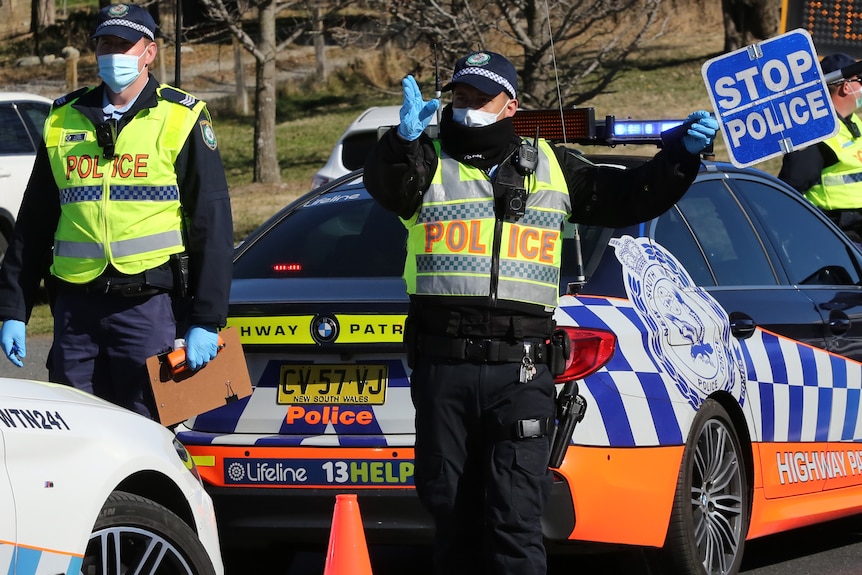 un policier sur la route avec un panneau arrêtant la circulation