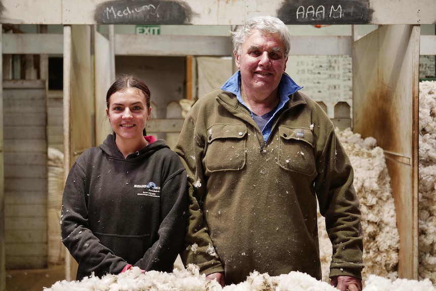 young woman wool handler and her mentor an older man in the shearing shed