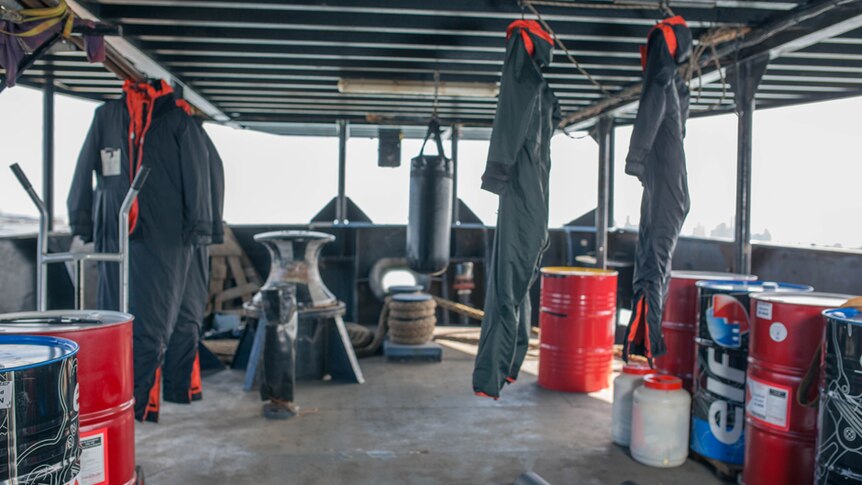Cold weather suits and punching bags hang on deck