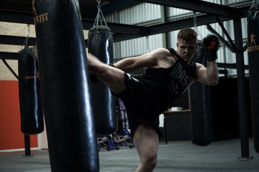 Jim Crute kicking a punching bag.