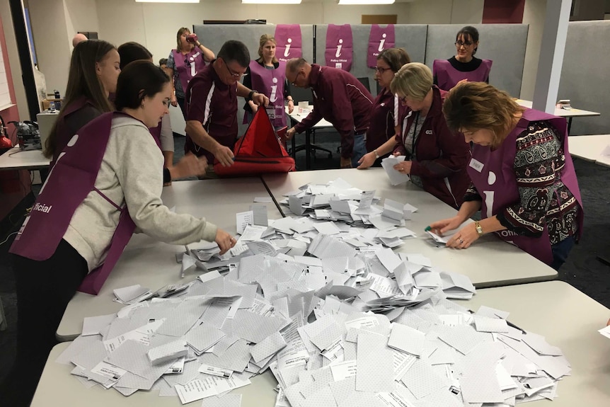 10 election volunteers count votes around a table at the Ipswich counting centre for the 2017 Mayoral election.