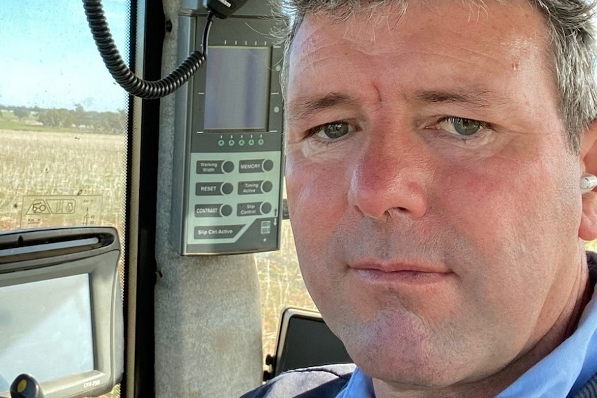 A man with short dark hair sitting in a tractor.