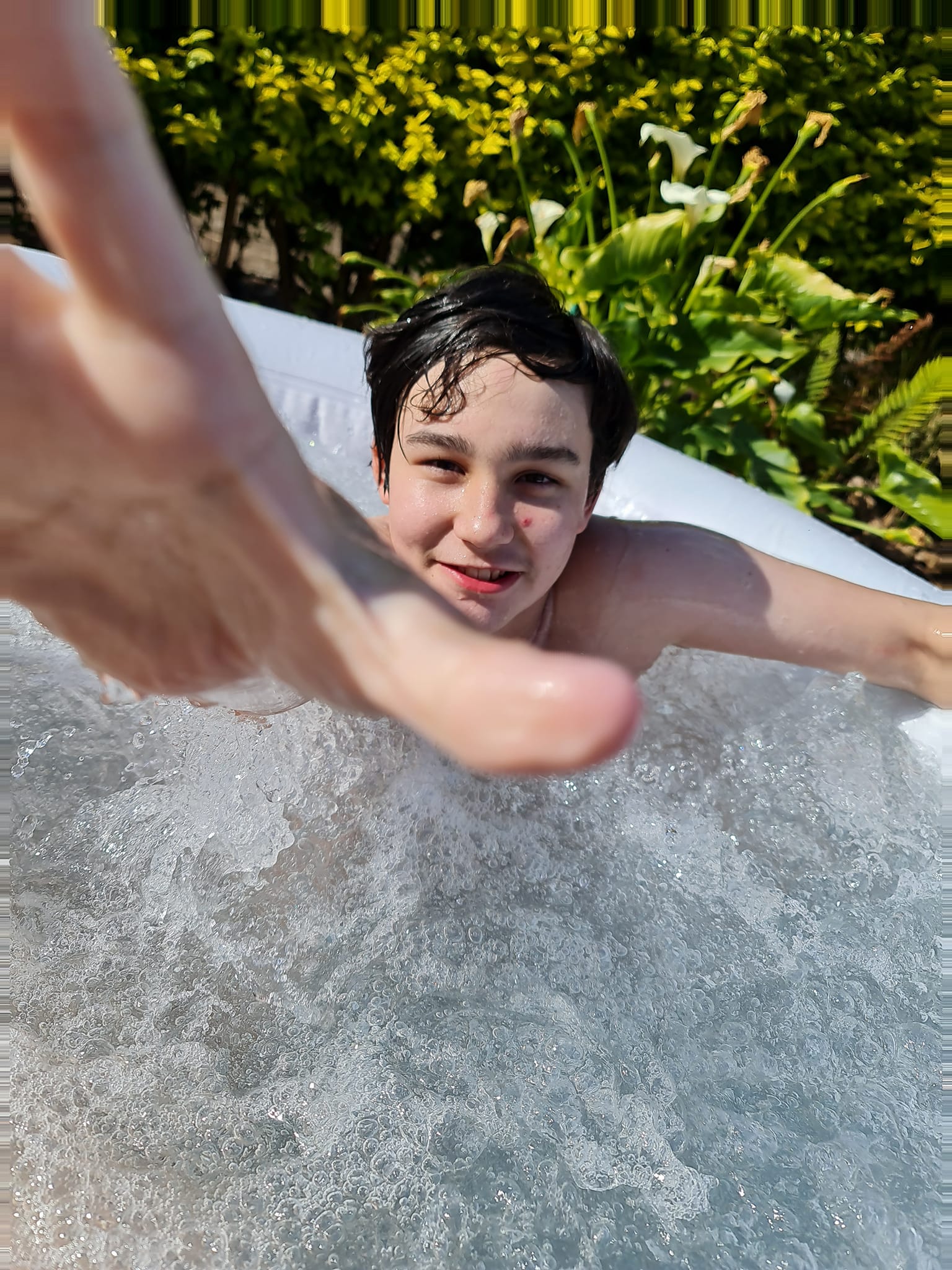 Zane Mellor in a pool reaches for the camera.