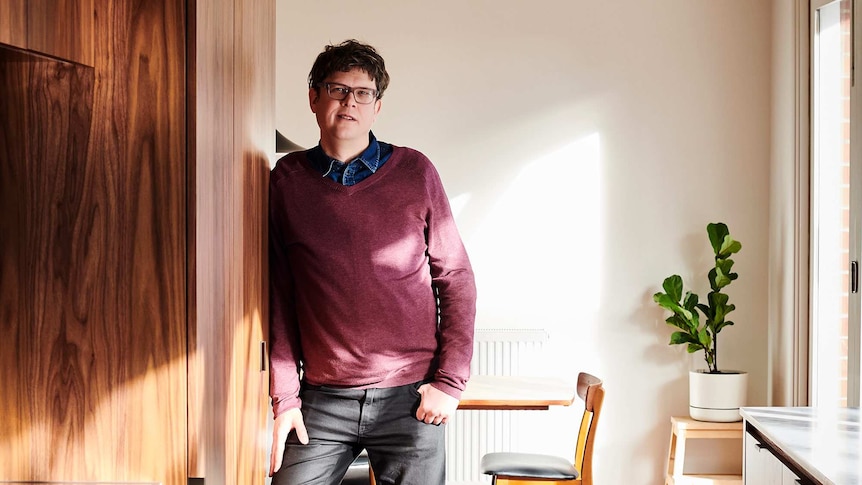 Architect and Restoration Australia host Stuart Harrison leans against a wall inside a recently-renovated home.