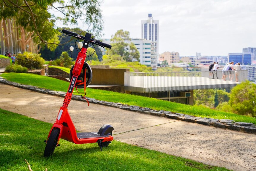 An orange e-scooter in Kings Park with views of Perth city in the background
