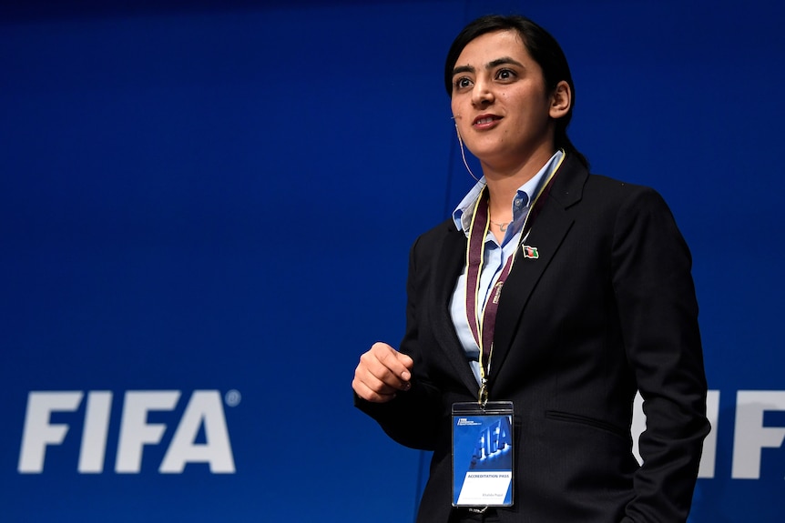 An Afghan woman speaks on stage at an international football inclusion conference in Switzerland.