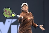 Tennis star Naomi Osaka looks down at the ball as she connects with a forehand during practice.