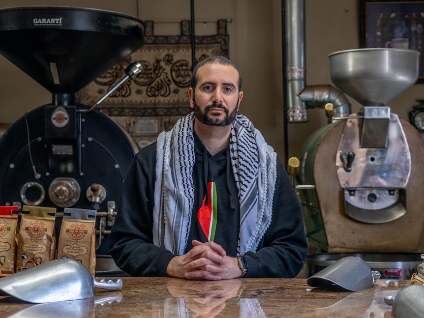 Mohammad Qazzaz at his coffee roastery with a Palestinian keffiyeh around his shoulders